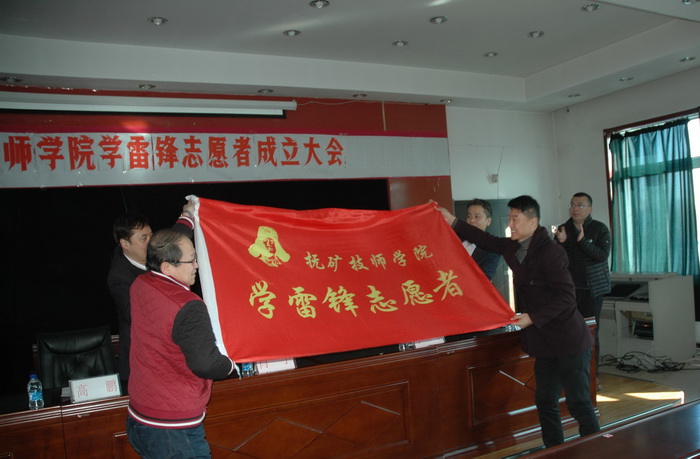 市雷锋办主任肖宇，文明办副主任于立冬为学院志愿者授旗.jpg